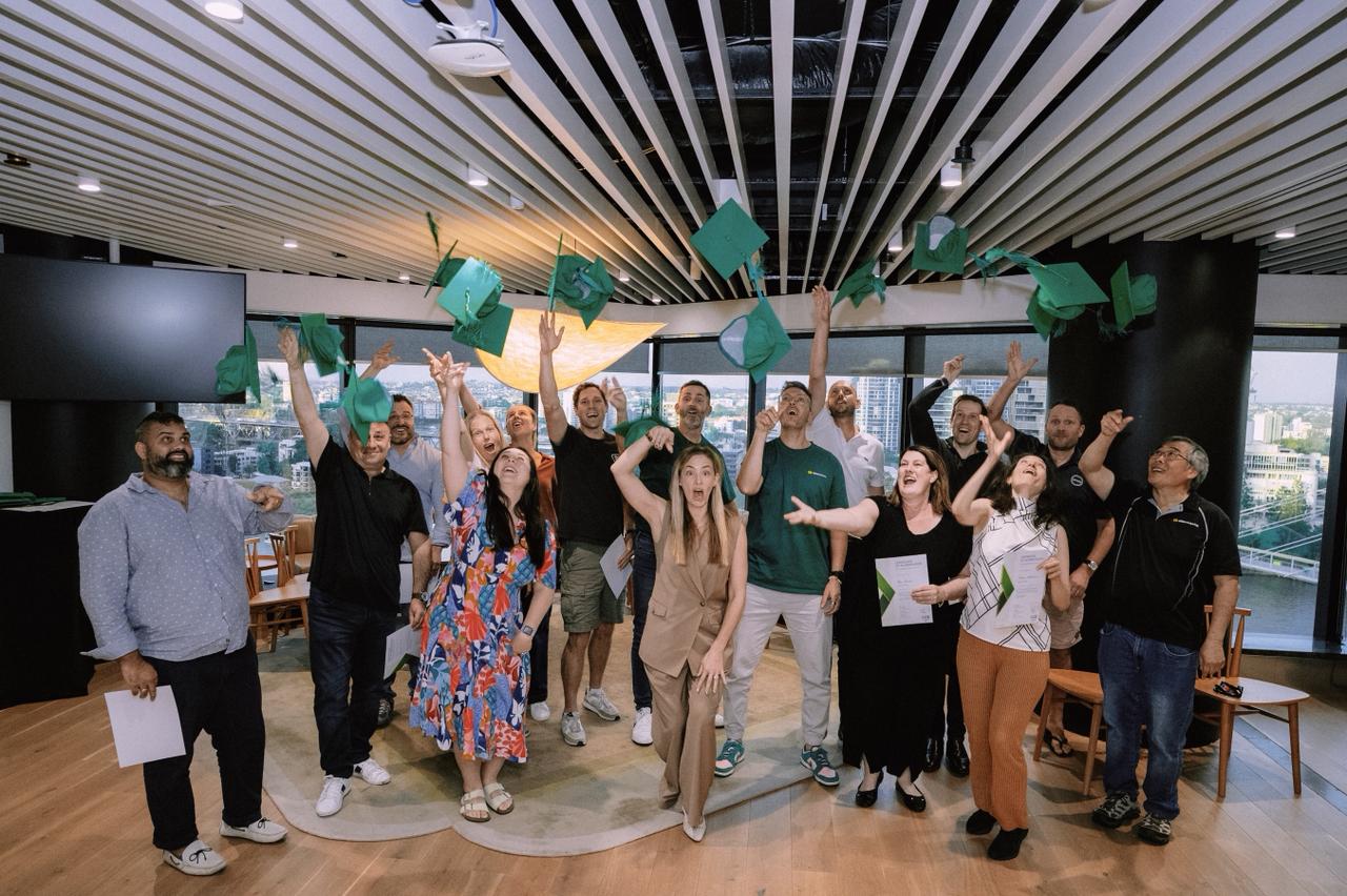 WizeAdvisory graduates throwing their caps in celebration